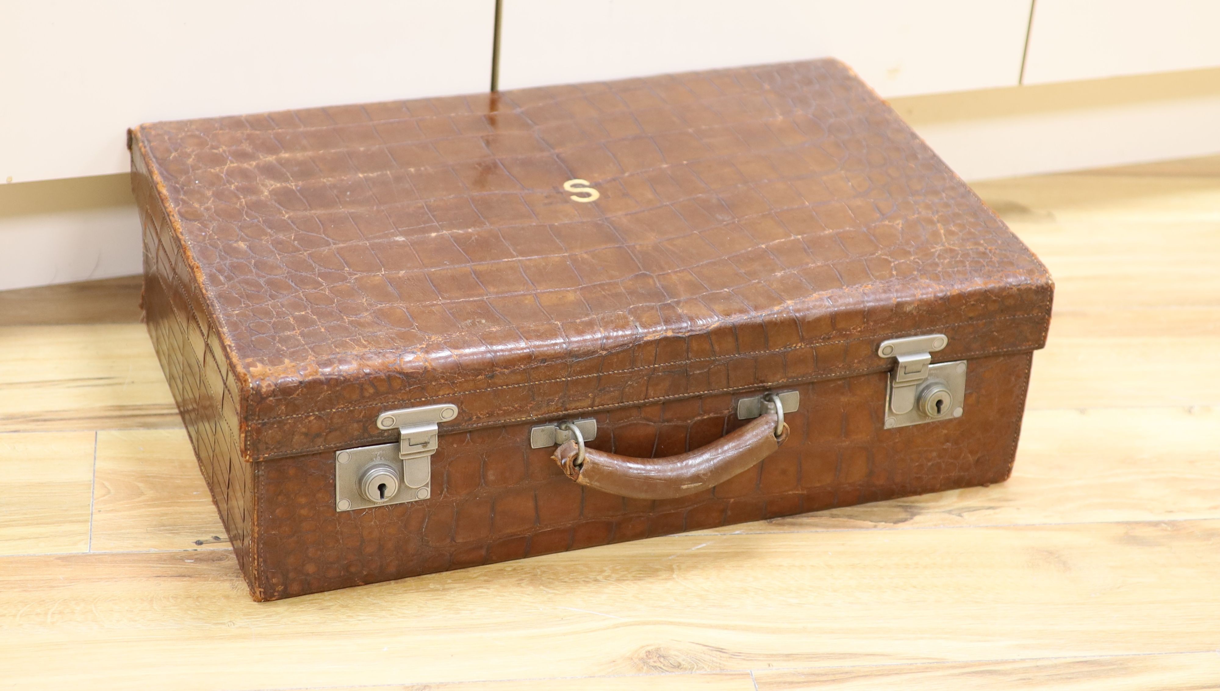 An early 20th century crocodile skin suitcase with blue leather lined interior 61cm